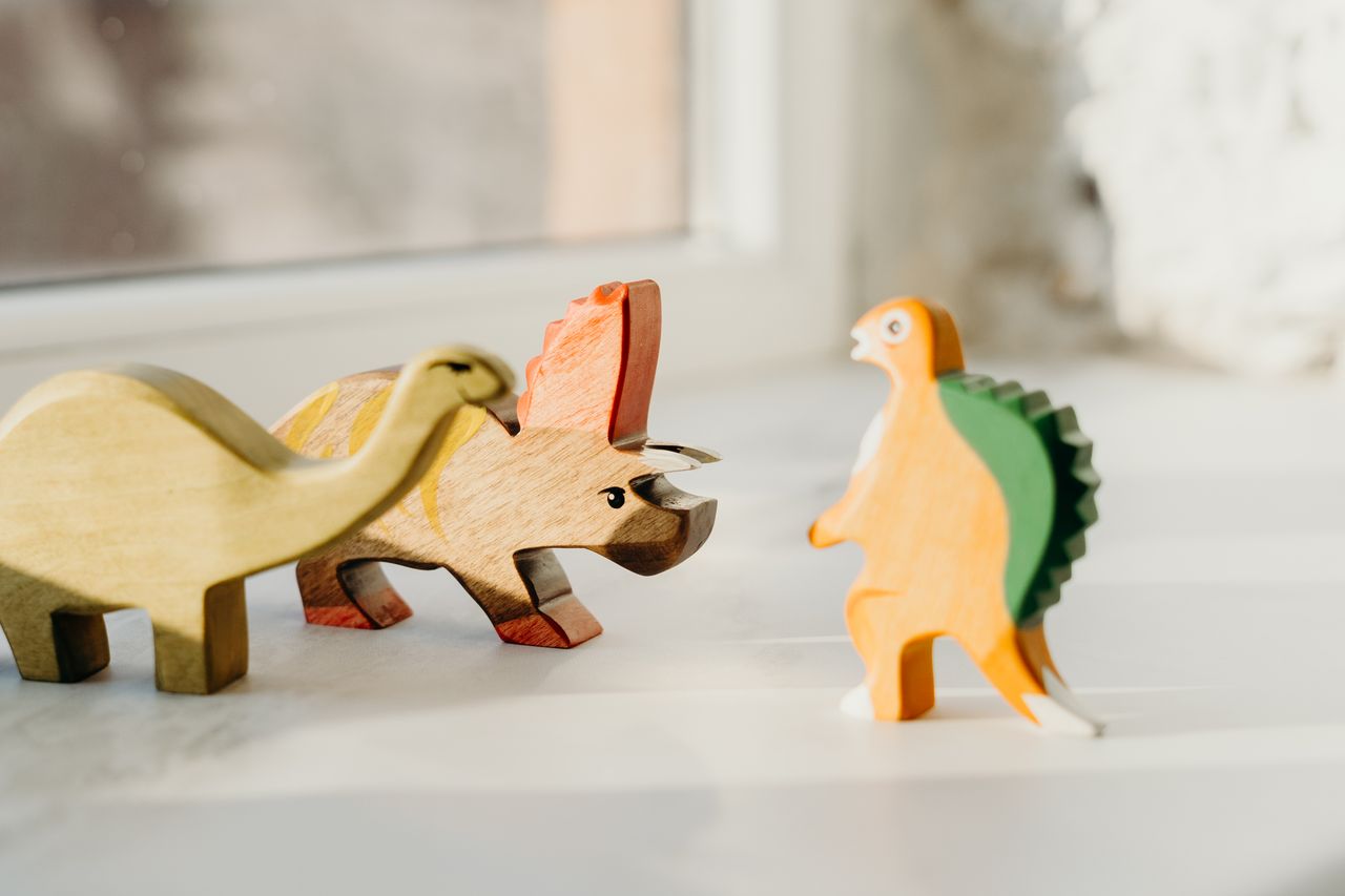Mastering the First Impression: Your intriguing post title goes here Engaging wooden dinosaur toys on a sunlit surface, perfect for children’s imagination.